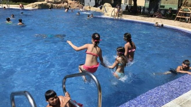 Niñas tirándose a una piscina al aire libre en verano en València