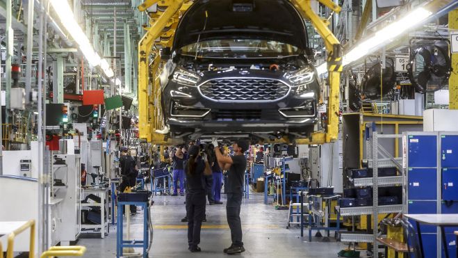 Dos trabajadores con un vehículo de la fábrica de Ford en Almussafes. Imagen de Rober Solsona