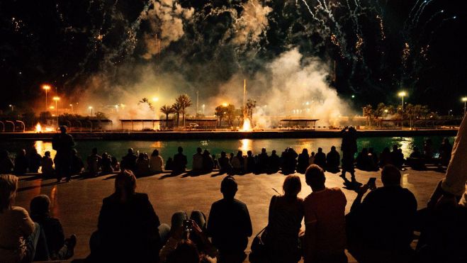 Un grupo de personas admiran un castillo de fuegos artificiales en La Marina de València