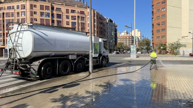 Un treballador realitza tasques de baldeig en un carrer de València