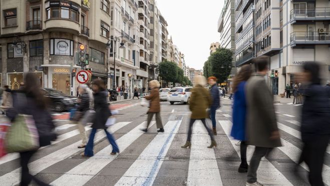 Diferentes personas cruzan un paso de peatones en el centro de València. Imagen: Xisco Navarro