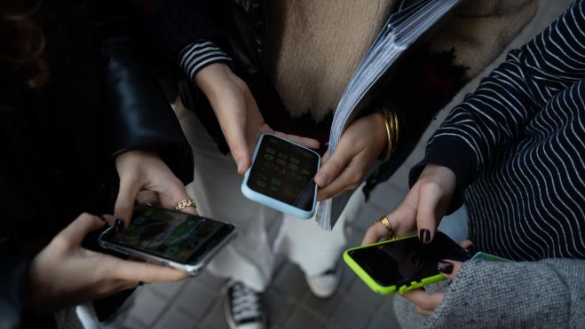 Tres adolescents usant un dispositiu mòbil. Imatge: David Zorrakino - Europa Press