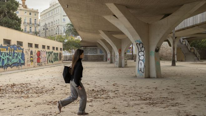 Una joven pasea por un parque de la ciudad de València. Imagen: Xisco Navarro