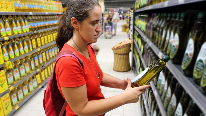 Una dona compra oli d'oliva a un supermerca