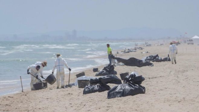 Los equipos de limpieza retiran el vertido en las playas del Saler. Imagen: Jorge Gil