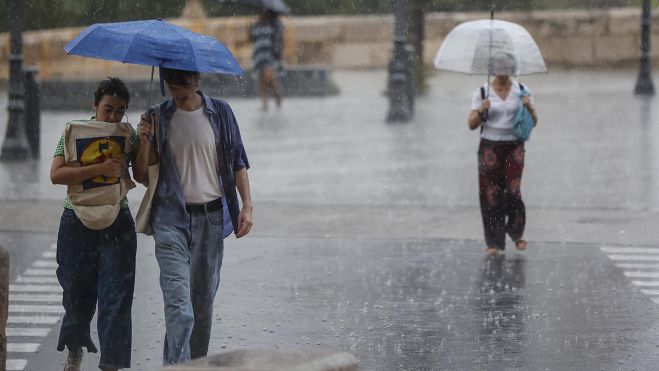 Varias personas con paraguas bajo la lluvia en Valencia. Foto Rober Solsona