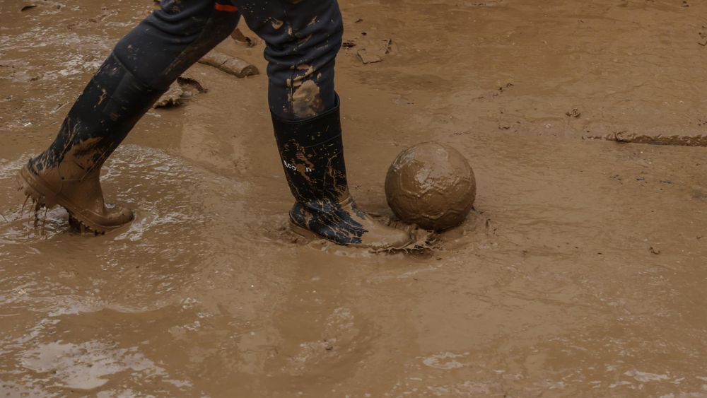 Un menor juega con la pelota en la zona afectada por la DANA